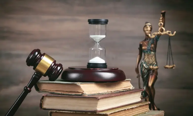 Hourglass and gavel on law books symbolizing Texas slip and fall filing deadline